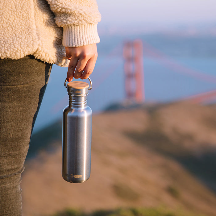 27oz-reflect-with-bamboo-cap-j9 K27SSLRF-BS-BAMBOO_reflect_bottle_bridge_lifestyle.jpg